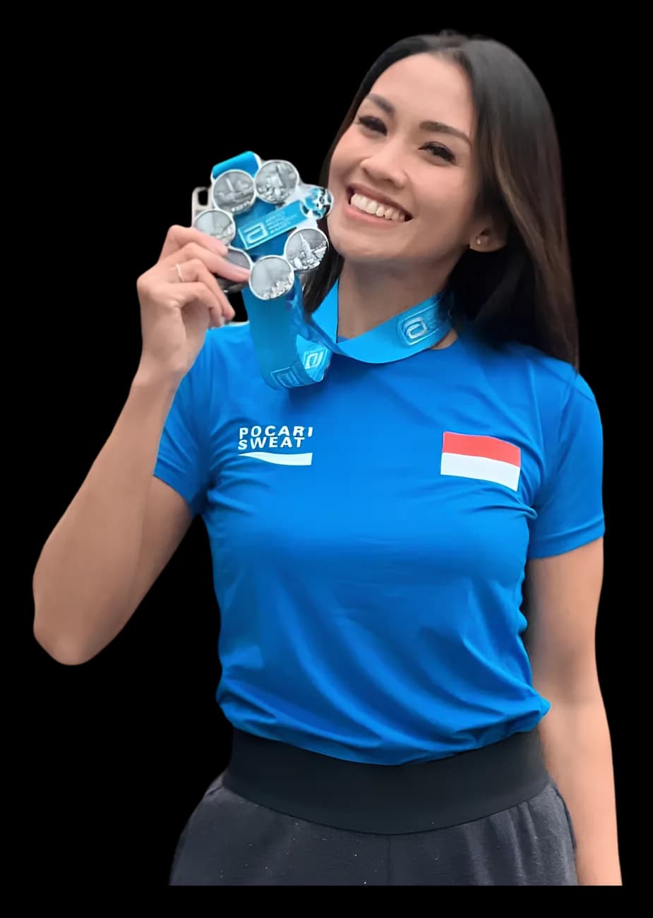 Mel tersenyum sambil memegang medali larinya